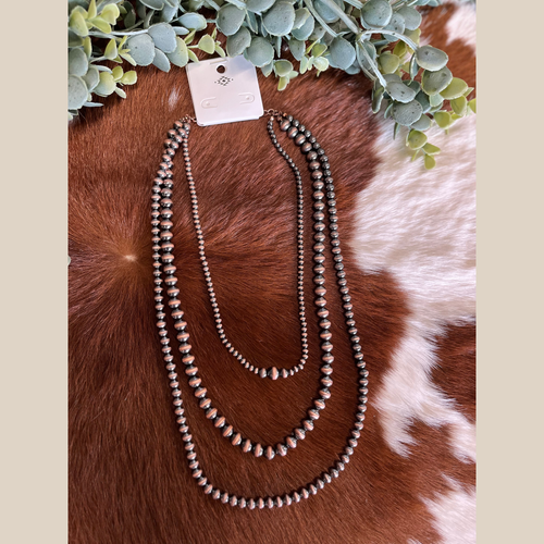Three-row copper Navajo style pearl necklace with layered design.