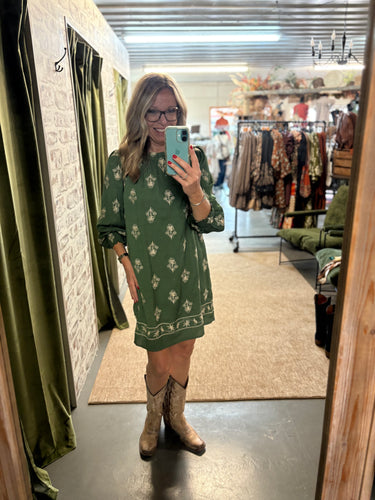 Woman in green Prairie Bloom Dress with 3/4 sleeves, lightweight, also comes in black.