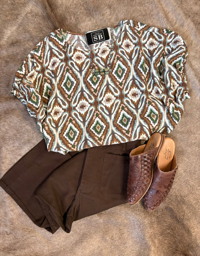Brown, ivory, and olive diamond print shirt, lightweight and true to size, styled with dark pants and woven mules.