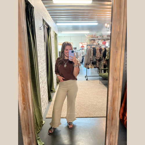 Straight-leg pants with ruffle hem, U-shaped front pockets, back zipper, available in black, olive, and taupe.