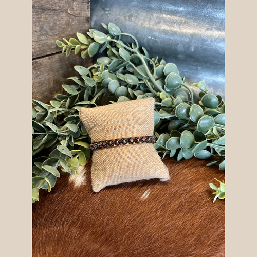 Copper cuff bracelet with embossed concho design.