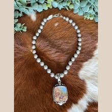 Load image into Gallery viewer, Navajo pearl style necklace with a western pendant depicting a cowboy and cactus scene.
