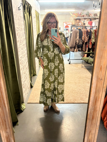 Woman wearing the Sagebrush Blooms Dress—green maxi dress with accent design, oversized fit, and pockets.