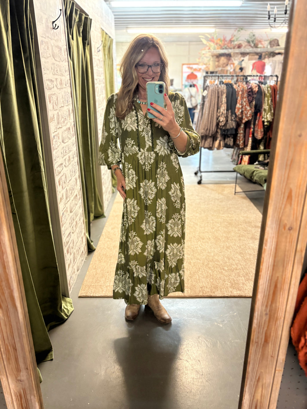Woman wearing the Sagebrush Blooms Dress—green maxi dress with accent design, oversized fit, and pockets.