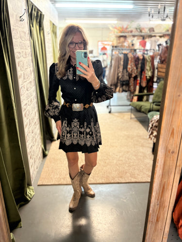 Woman wearing Black Aztec Dress with pearl snaps and Aztec print, styled with a Longhorn belt.