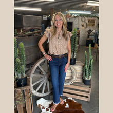Load image into Gallery viewer, Woman wearing a floral print ruffle sleeve top, standing indoors in front of cacti and a rustic wooden wagon wheel.
