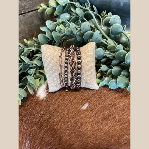 Four copper bracelets: Navajo-style pearl, twisted rope, and chain design.