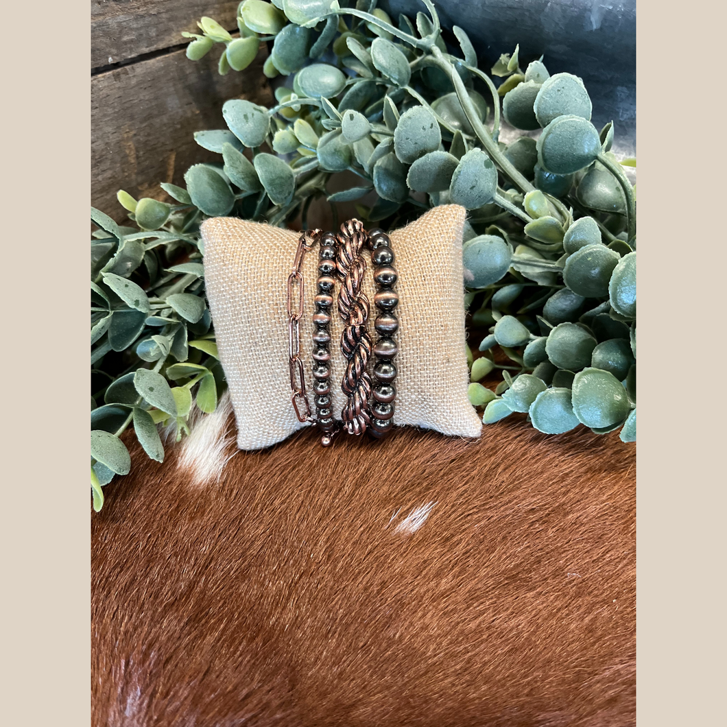 Four copper bracelets: Navajo-style pearl, twisted rope, and chain design.
