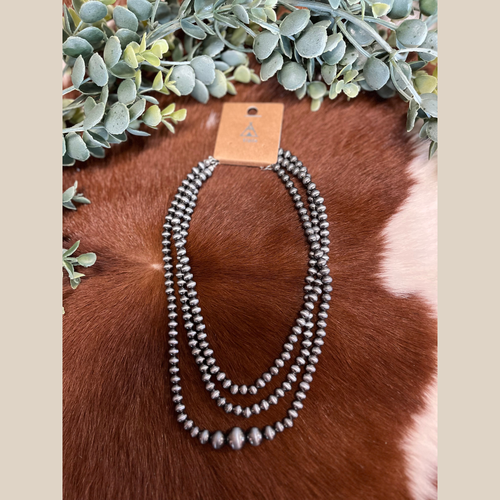 Three-strand Navajo style pearl necklace with graduated beads on the longest strand.
