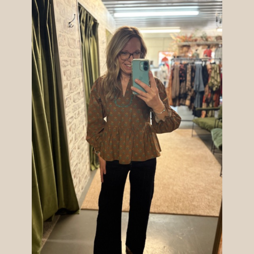 Woman wearing The Meadow Swing Top, a brown floral peplum blouse with V-neckline and rikrack trim detail.
