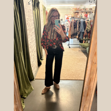 Load image into Gallery viewer, Woman wearing black floral blouse with patterned trim, relaxed fit, and long sleeves.
