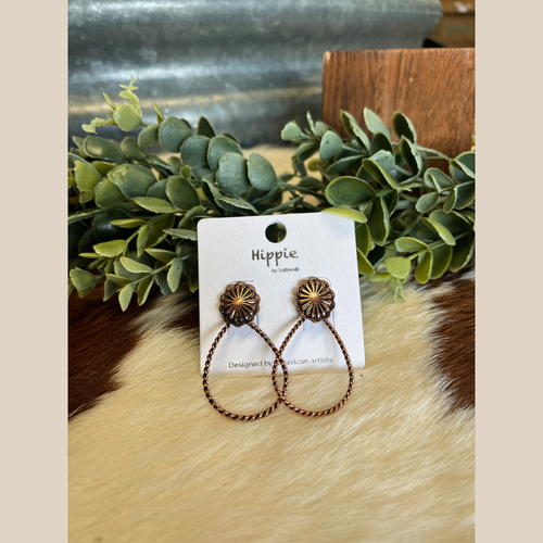 Pair of copper earrings in a twisted teardrop shape.