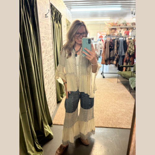 Woman wearing vintage denim latte jacket with lace patchwork, flowy sleeves, and pants.