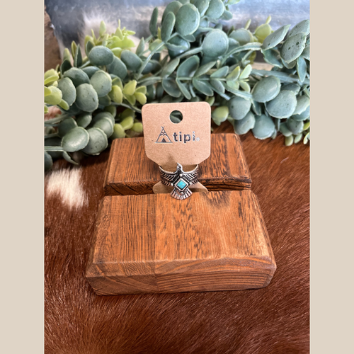 Thunderbird cuff ring with a small turquoise stone accent.